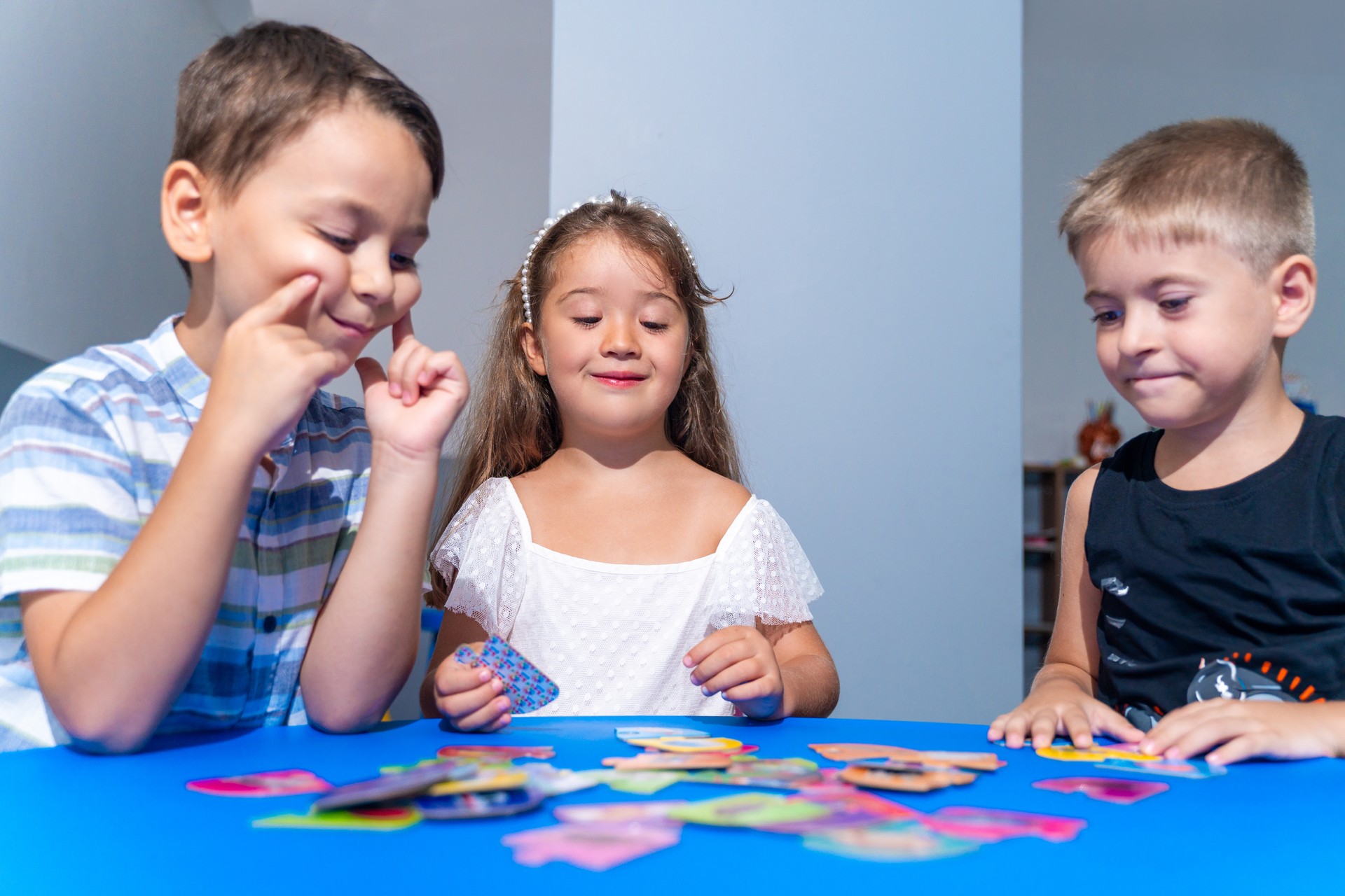 Explorative process Kindergarten students in classroom playing cognitive game activities, decoding puzzles that boost logical thinking and motor skills, all within an interactive learning environment